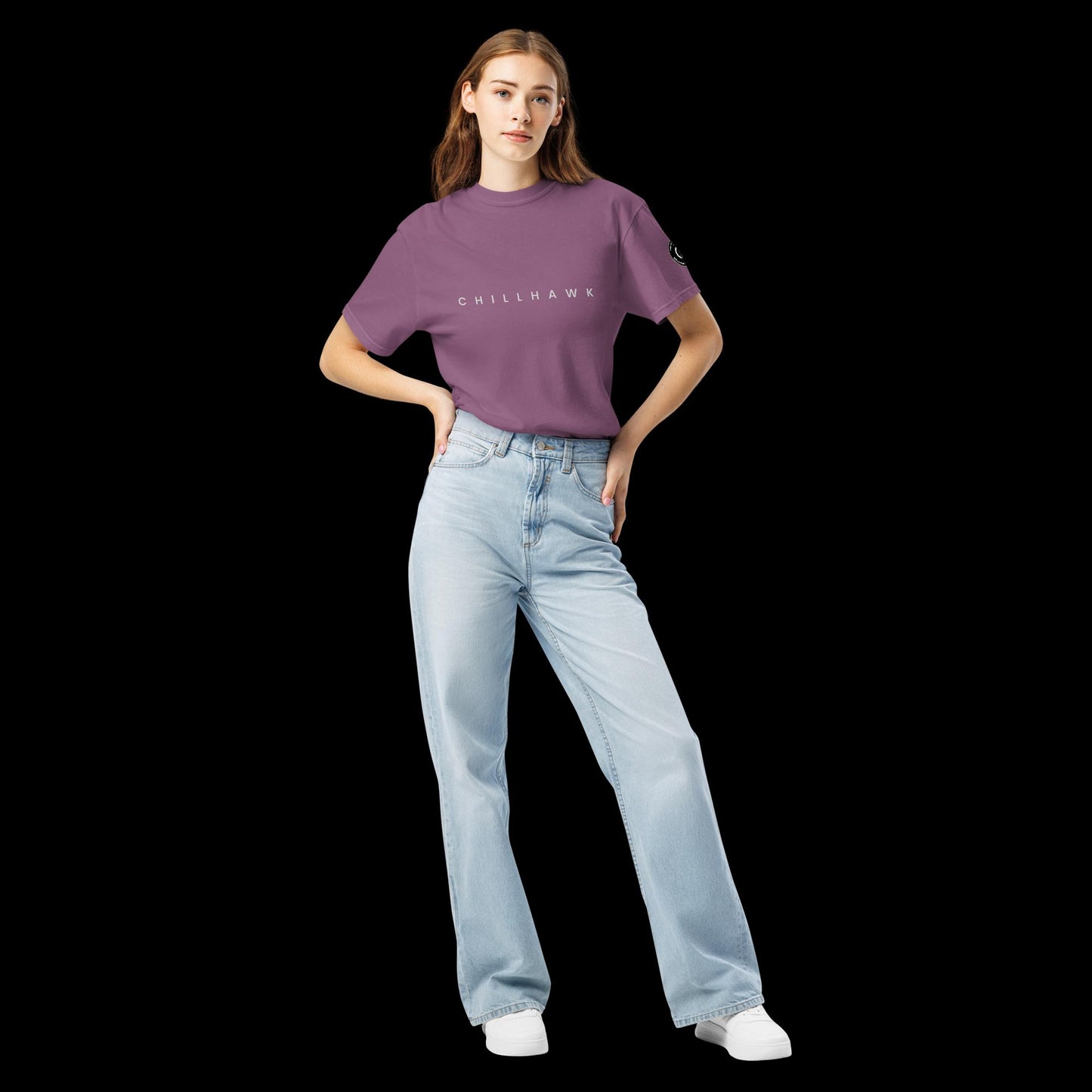 Chillhawk unisex heavyweight short sleeve t-shirt in berry - front view of a lady with light skin and long brown hair, is wearing the t-shirt and light blue jeans. The word "CHILLHAWK" is printed in black on the front of the shirt, and a circular logo is visible on the left sleeve.